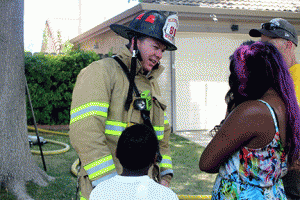 A firefighter consoles a family after a fire in Oakley on Sunday